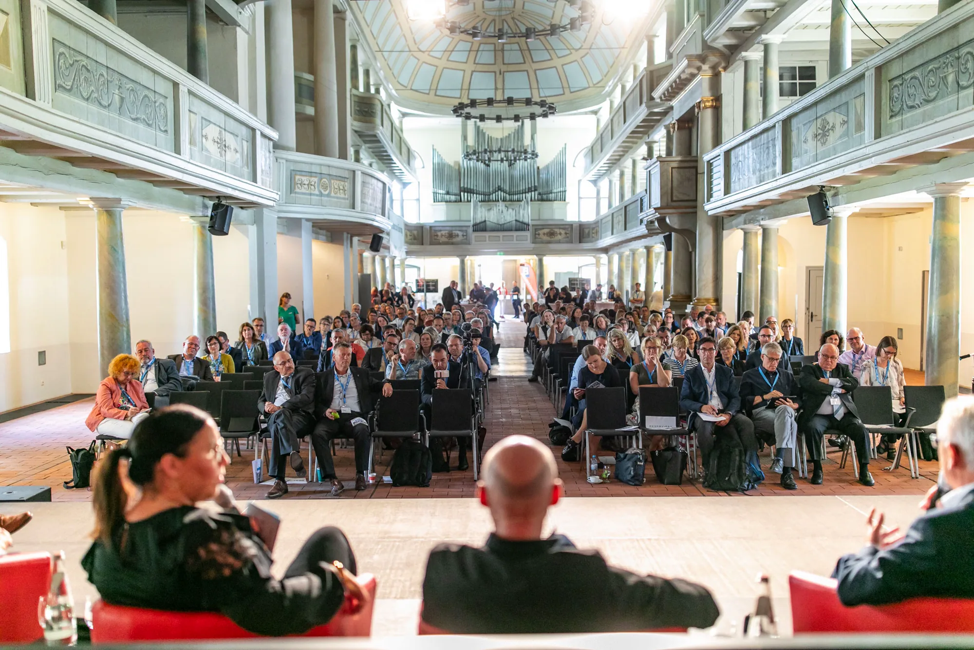 Gut besuchte Fachtagung mit Bühne und aufmerksamem Publikum